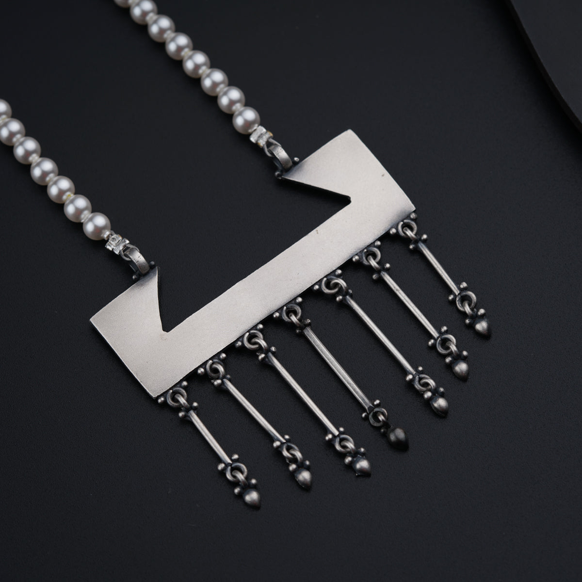 a necklace with a metal arrow on it