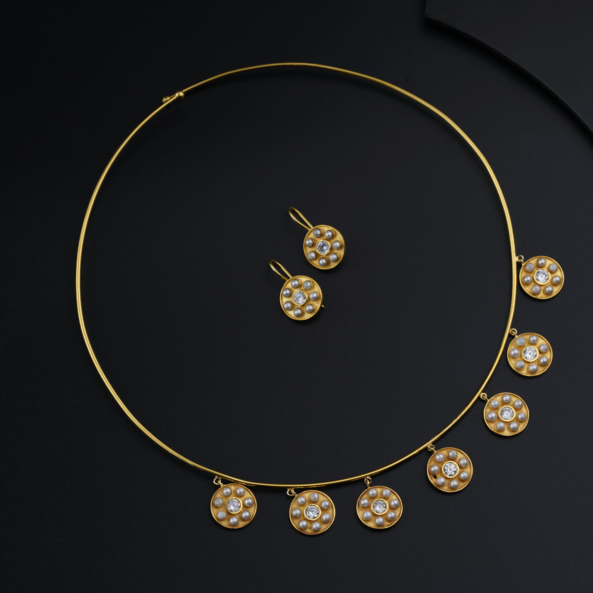 a gold necklace and earring set with pearls