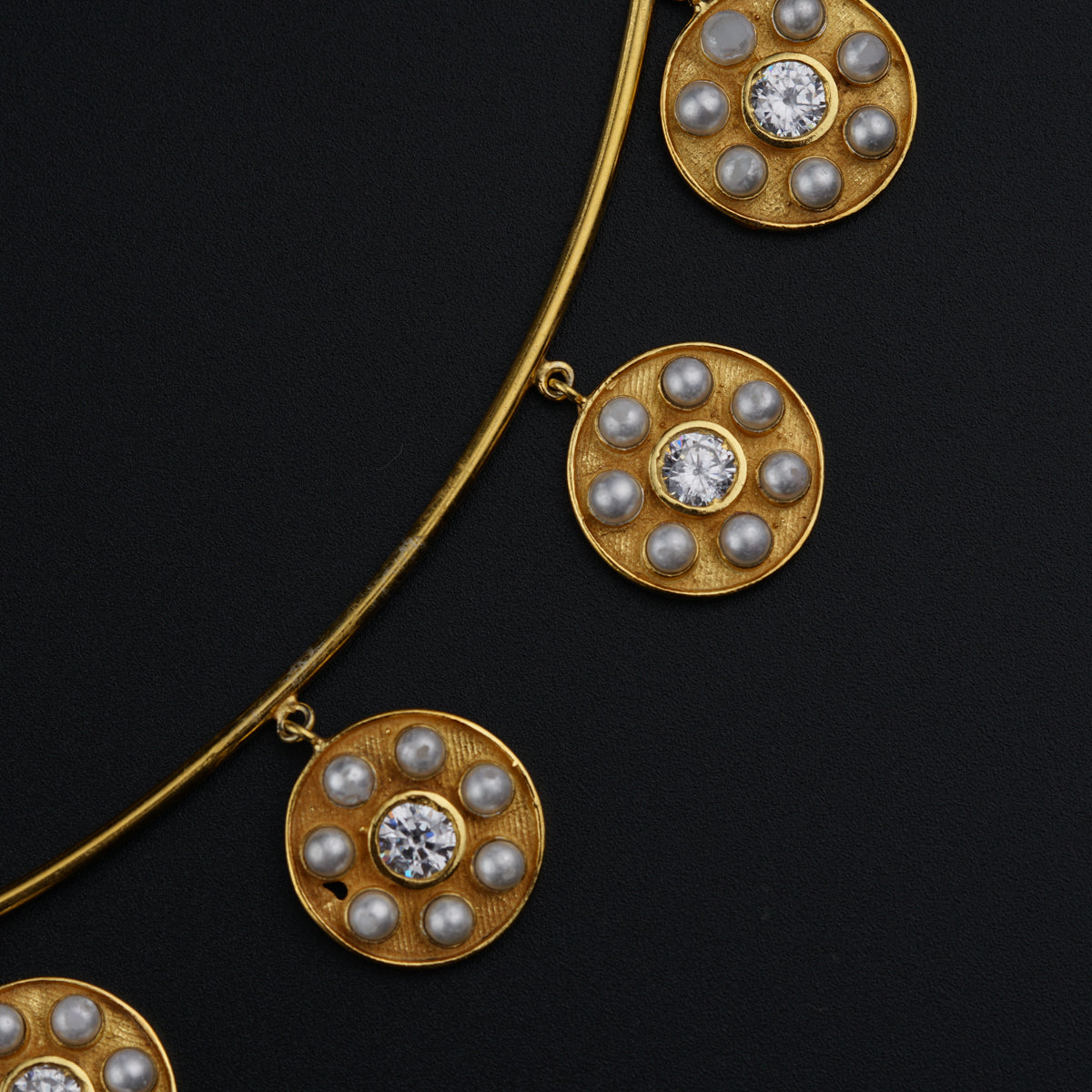 a close up of a necklace on a black surface