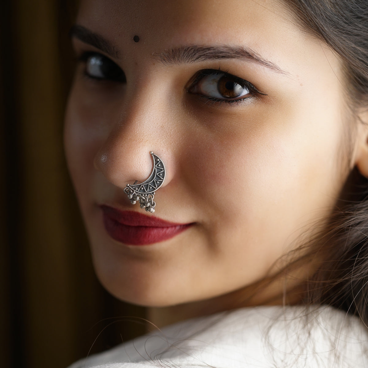 a close up of a woman with a nose ring