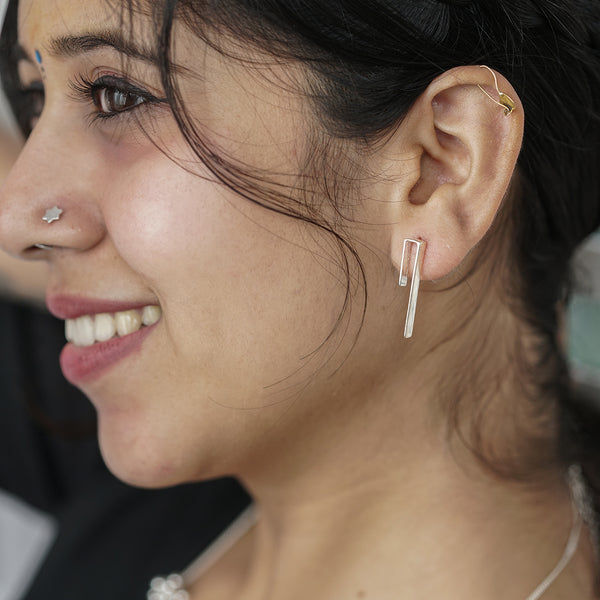 Woman wearing silver minimalist earrings