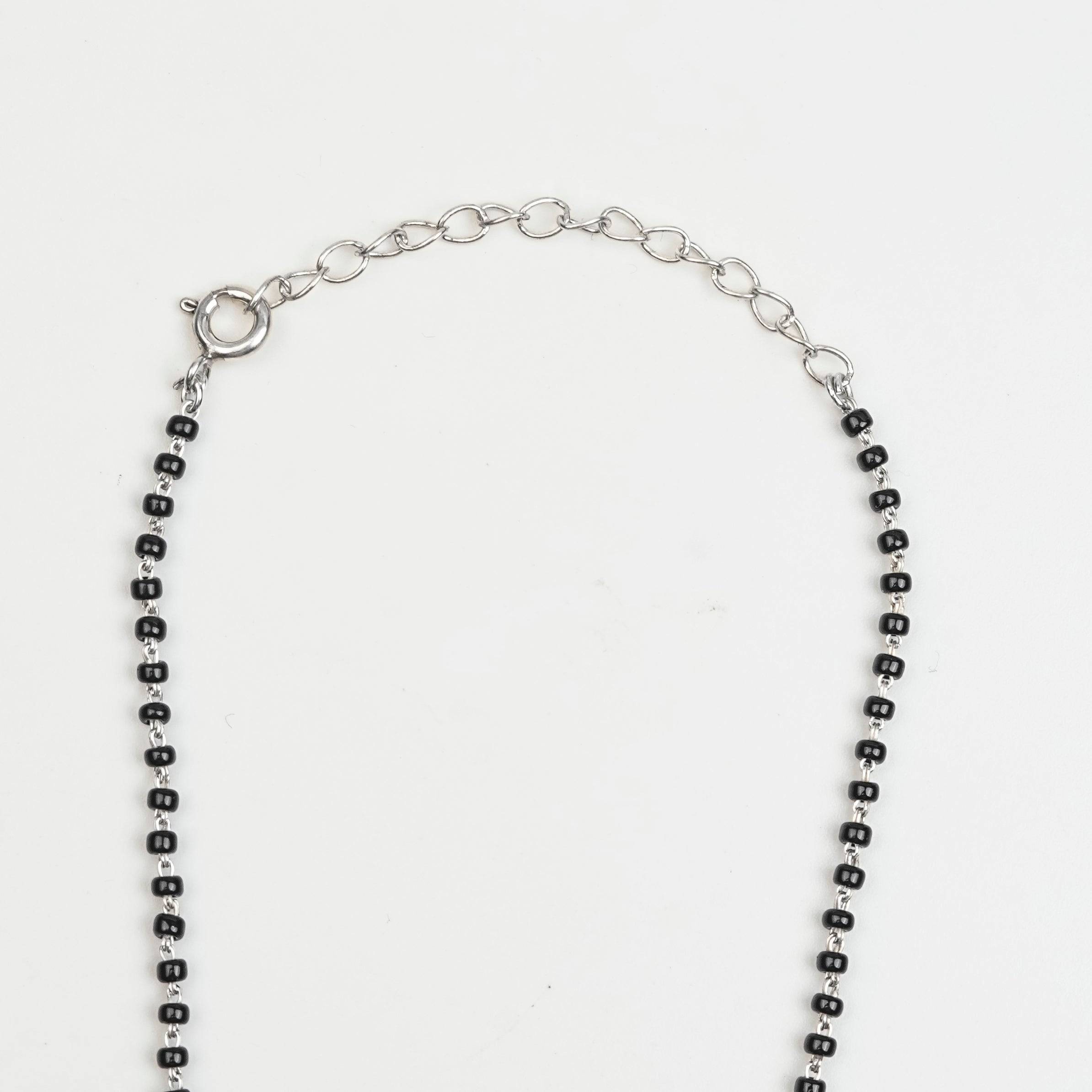 Flat-lay of Silver Oxidized Dome Mangalsutra with traditional accessories on a premium styling setup