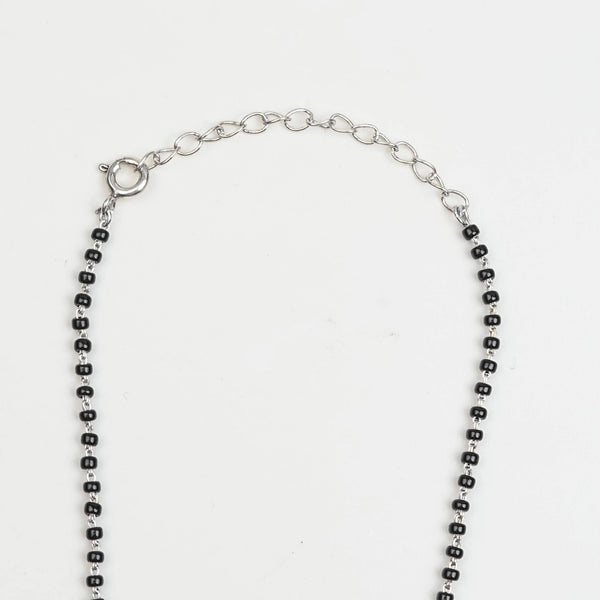 Flat-lay of Silver Oxidized Dome Mangalsutra with traditional accessories on a premium styling setup