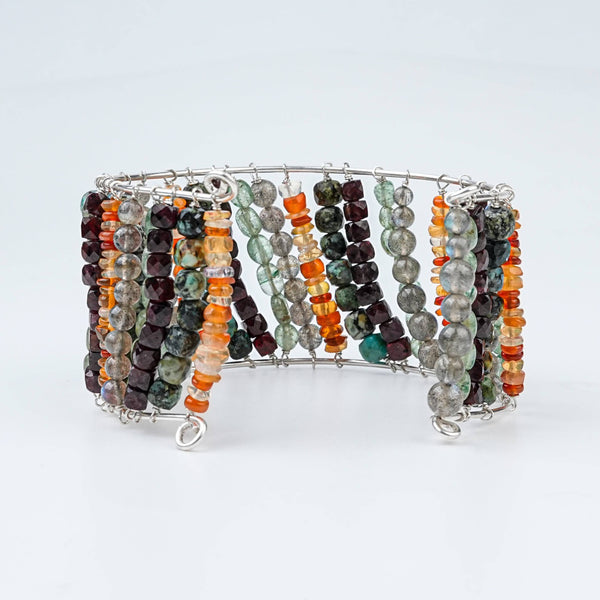 Flat-lay of a multicolour semi-precious stone silver bracelet with colourful natural gemstones and complementary silver jewelry
