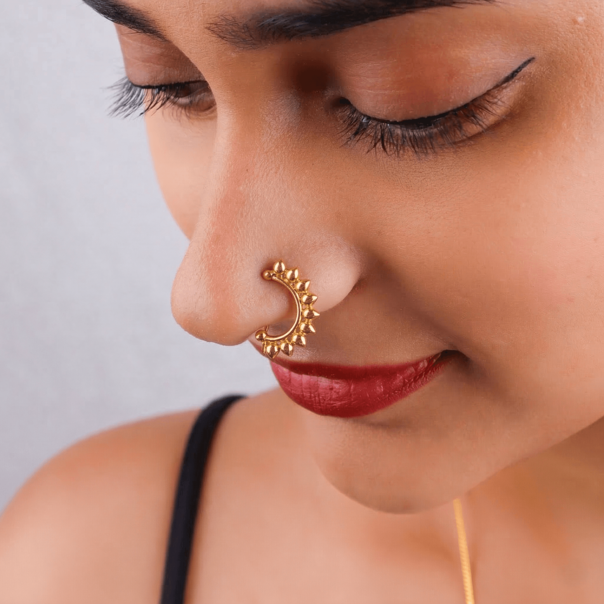 Close-up of gold-tone floral nose ring