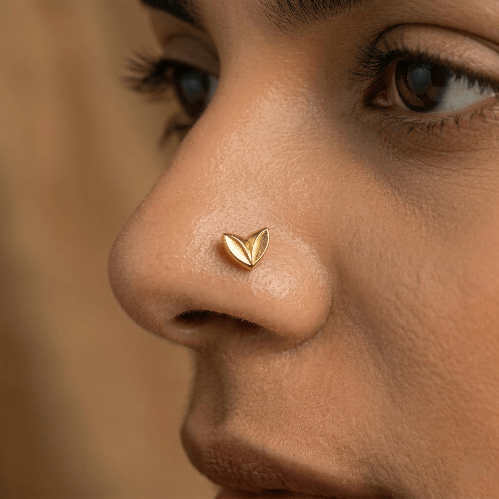 Close-up of gold heart nose pin on skin