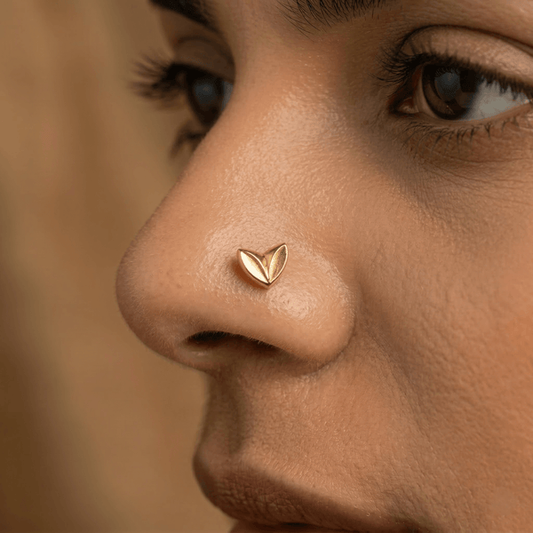 Close-up of gold heart nose pin on skin