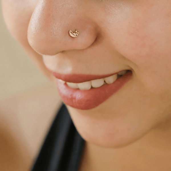 Close-up of gold nose pin on skin