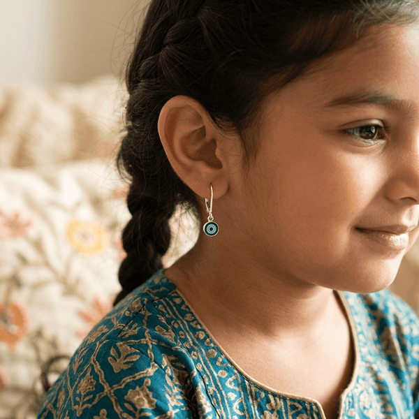 Close-up of earrings worn by girl with braided hair