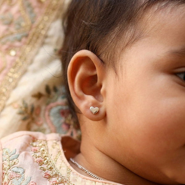 Woman wearing silver heart stud earrings