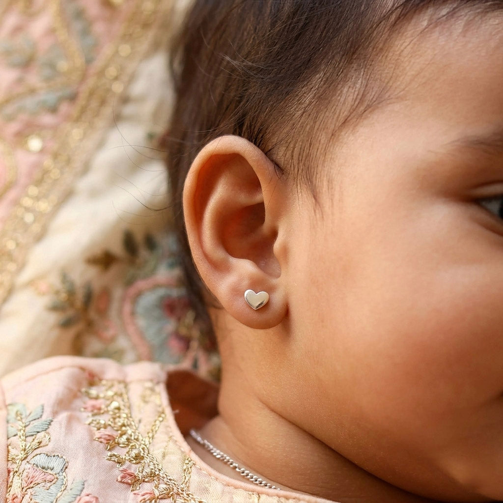 Woman wearing silver heart stud earrings