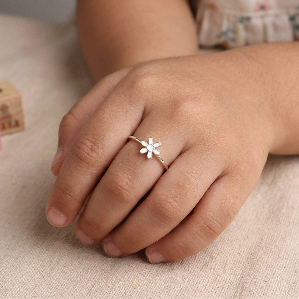 Woman wearing white flower enamel ring on finger