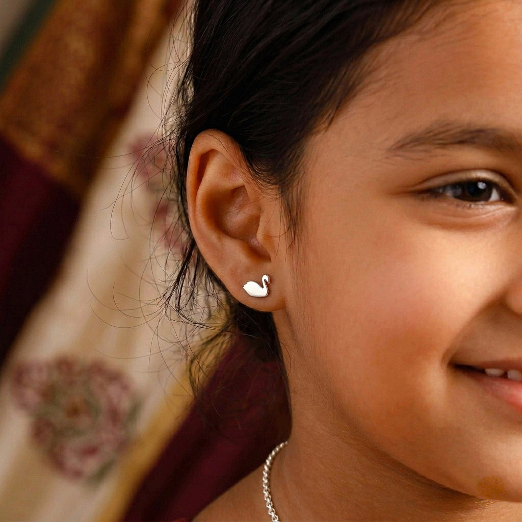 Woman wearing silver swan stud earrings