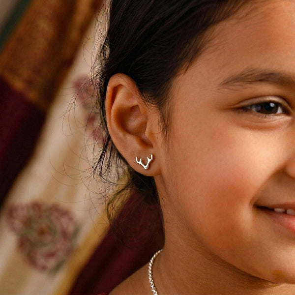 Woman wearing silver deer horn studs earrings