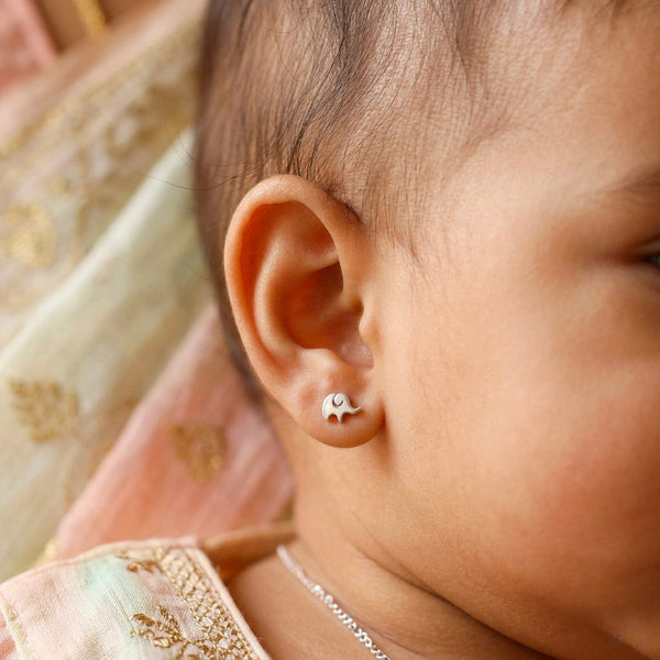 Child wearing silver elephant stud earrings