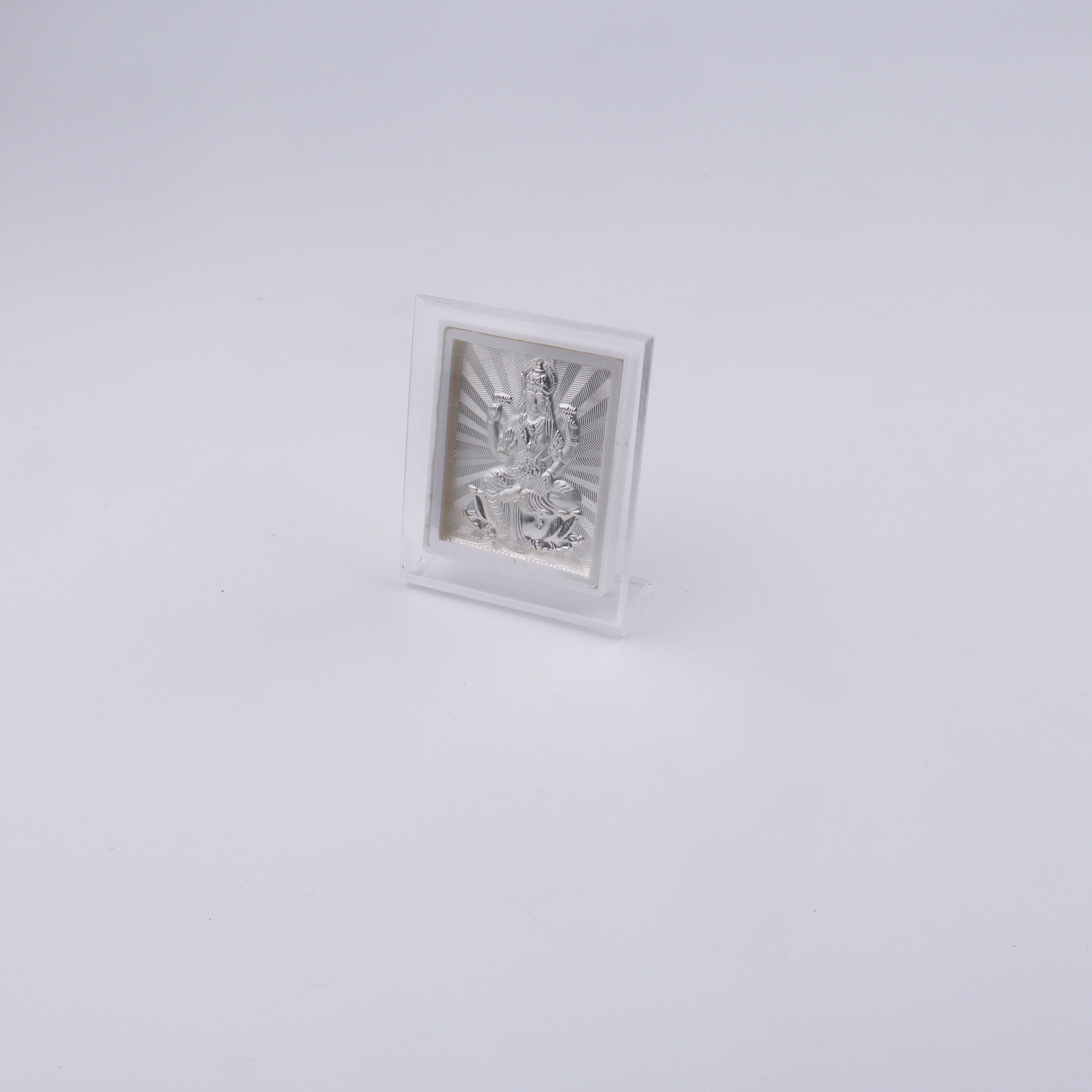 Silver deity statue in a clear box on a white background