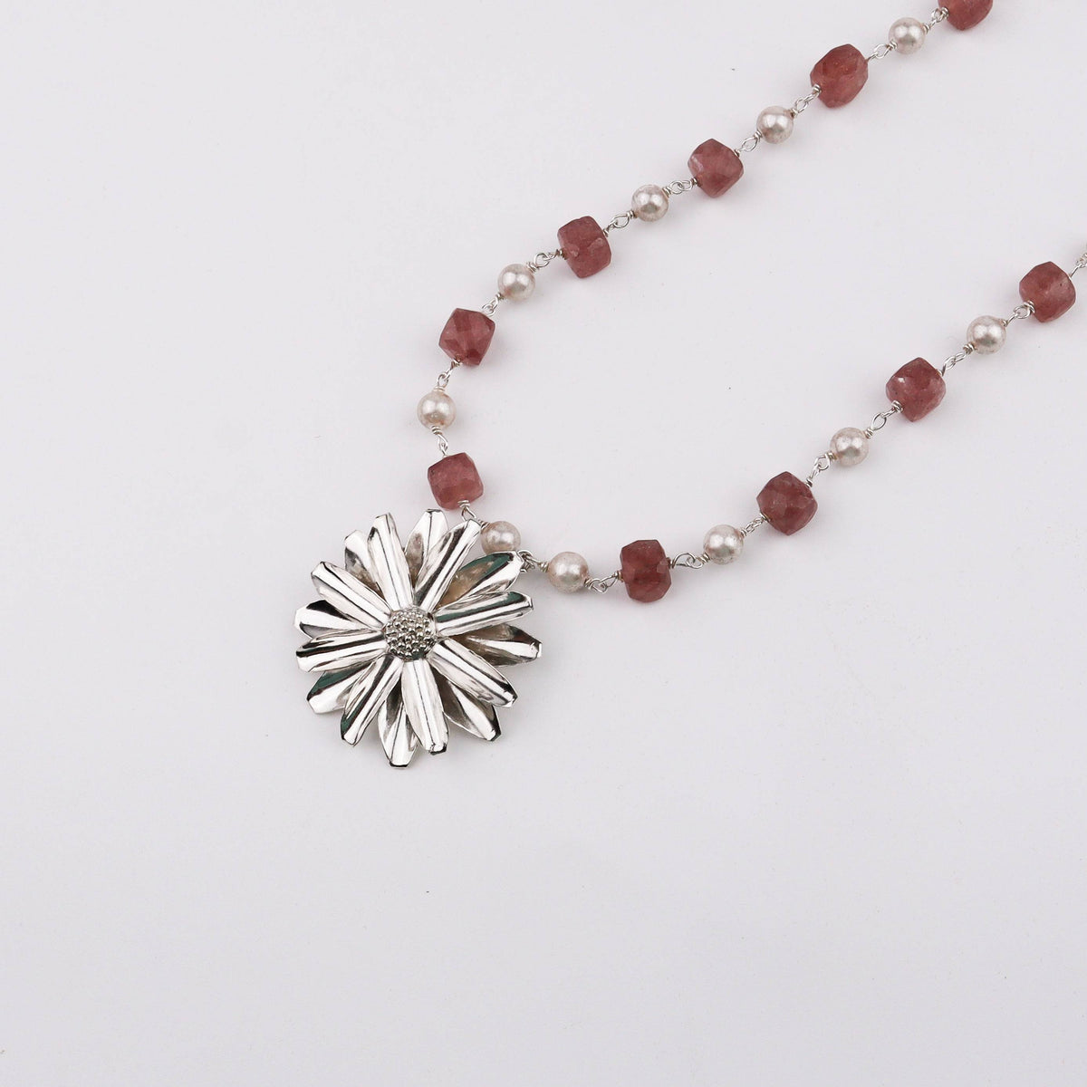 Close-up of Silver Soorajmukhi Pendant with pink strawberry cubes