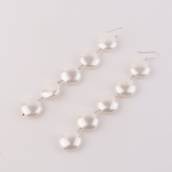 Close-up of pearl earrings with silver hooks