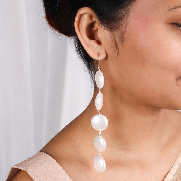 Model wearing long pearl drop earrings