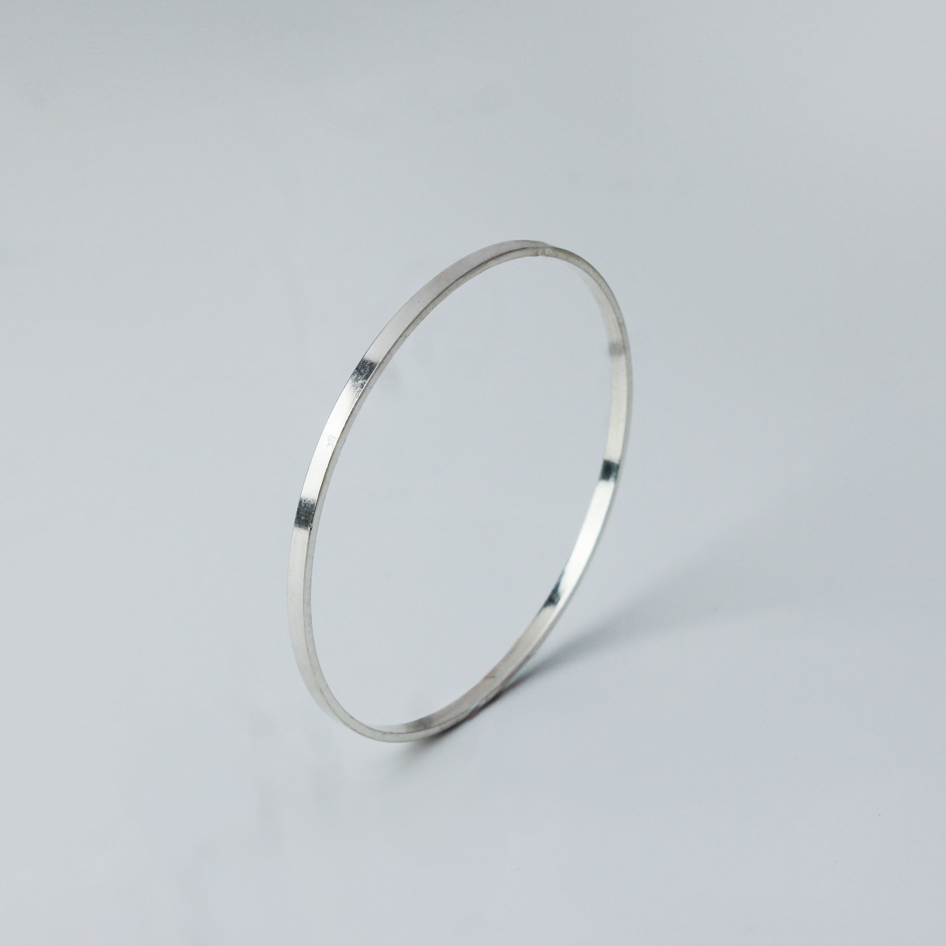 Silver bangle with flat shape on white background