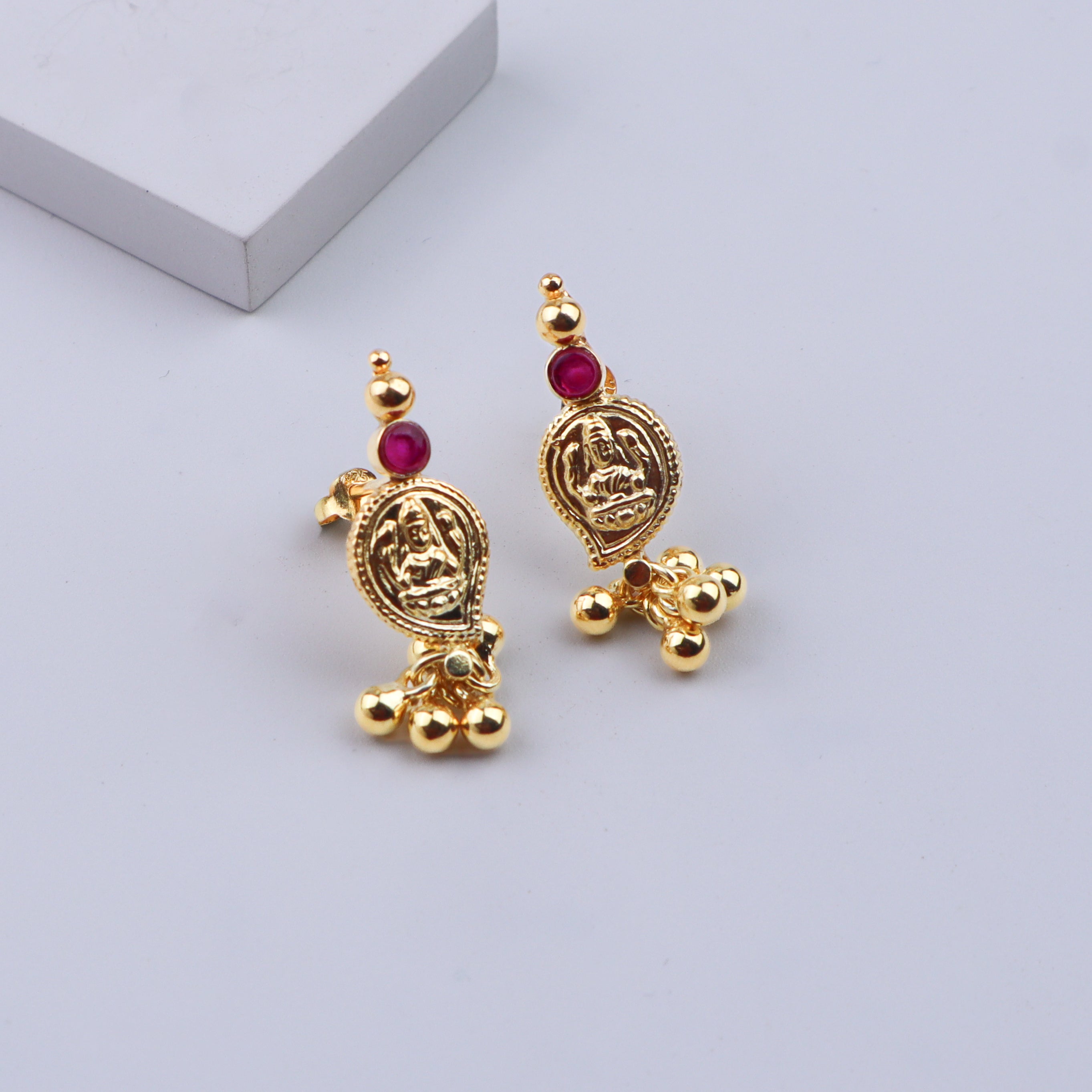 Gold earrings with traditional design and red stones