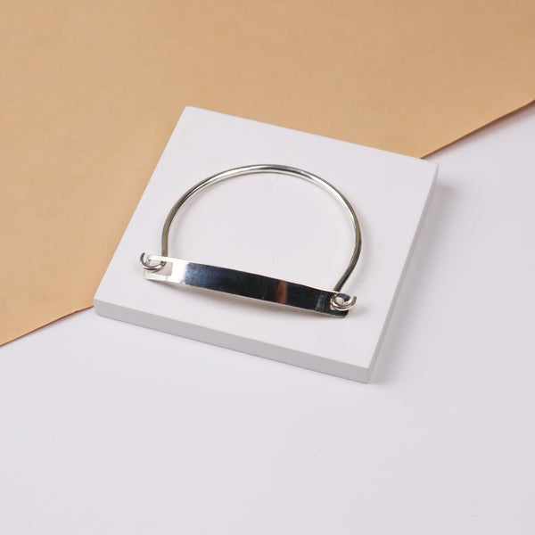 Silver bracelet on white jewelry stand