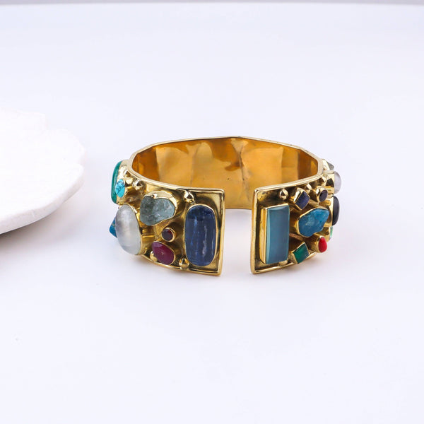 Angled view of a brass fashion bracelet highlighting its unique silhouette, structure, and polished brass finish