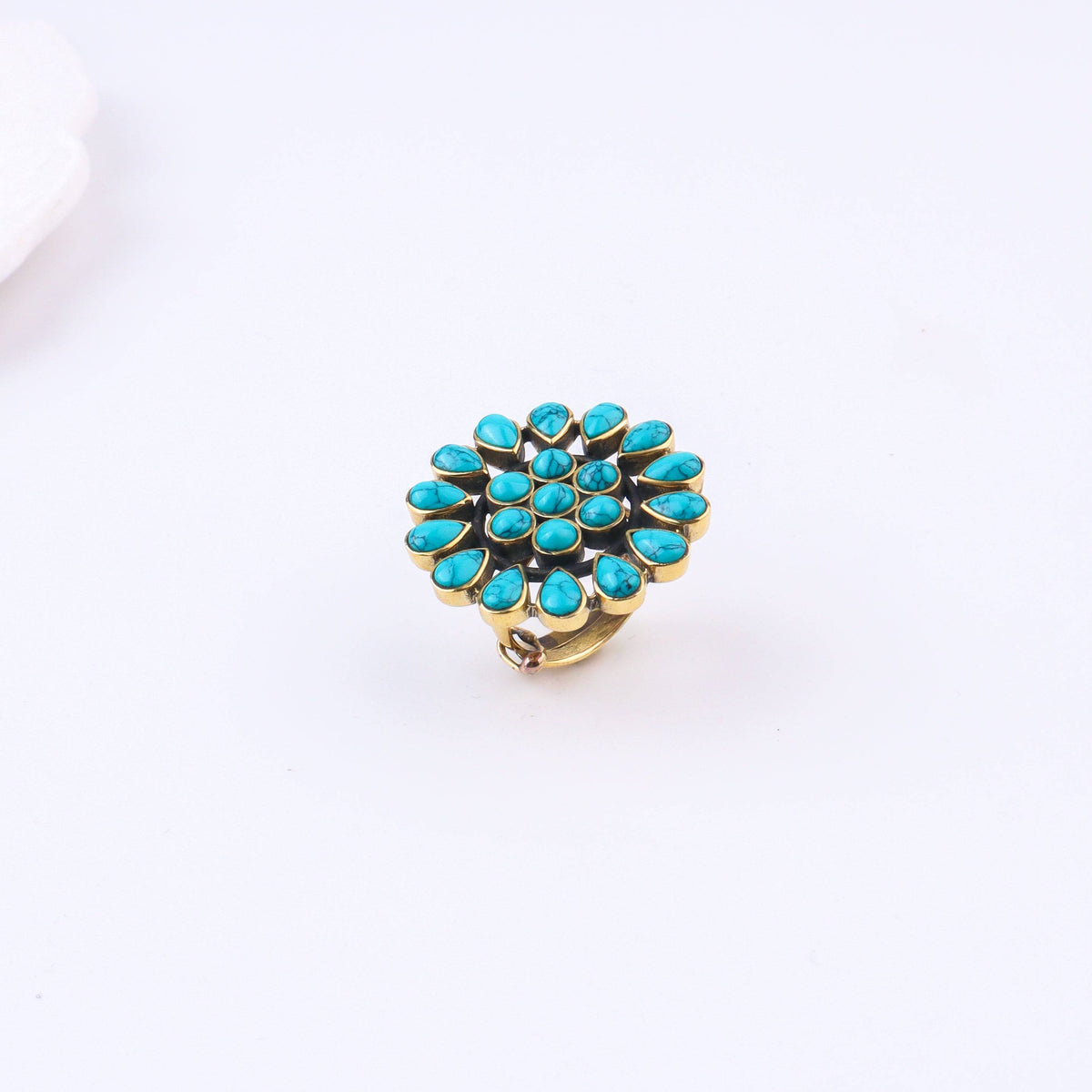 Detailed view of a brass fashion ring highlighting intricate motifs, textured surface, and refined brass finish