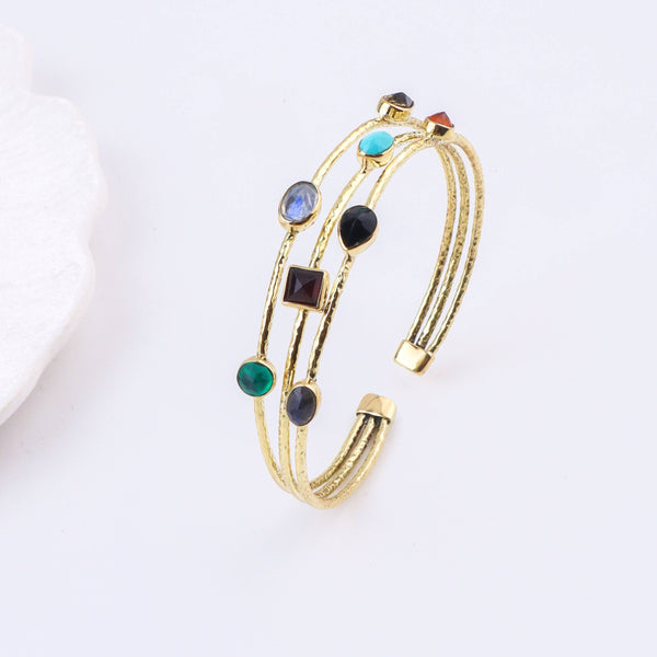 Angled view of a brass fashion bracelet highlighting its unique silhouette, structure, and polished brass finish