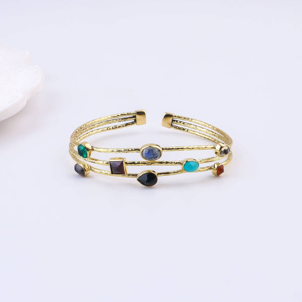 Detailed view of a brass fashion bracelet highlighting intricate motifs, textured surface, and refined brass finish