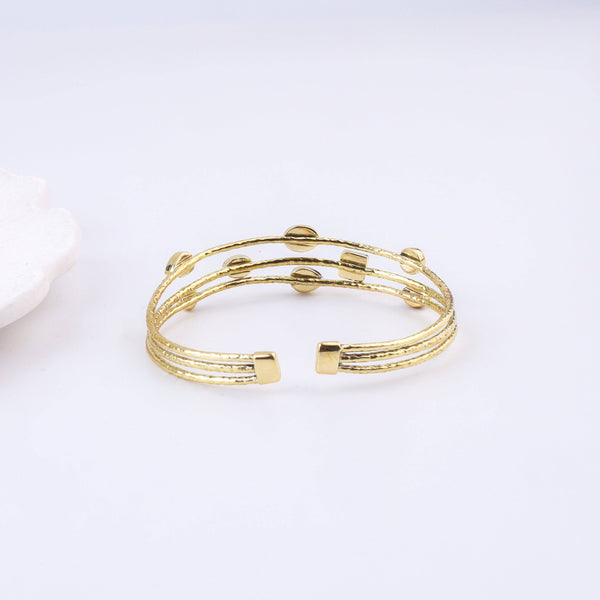 Model styling a brass fashion bracelet with an elegant ethnic outfit for a statement jewellery look