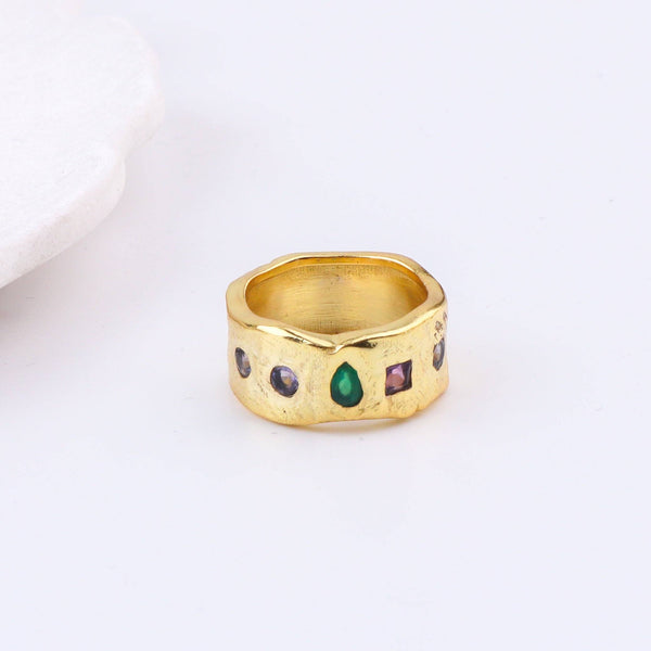 Flat-lay of a brass fashion ring with complementary jewellery and accessories for a chic styling setup