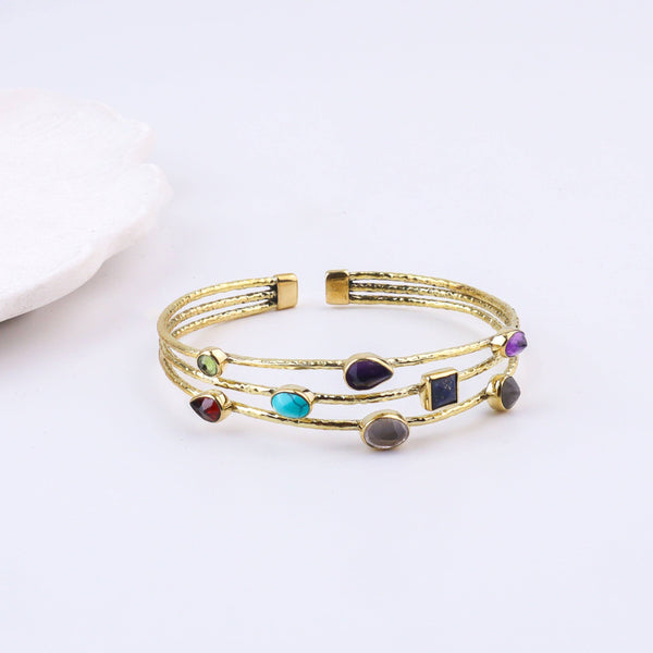 Detailed view of a brass fashion bracelet highlighting intricate motifs, textured surface, and refined brass finish