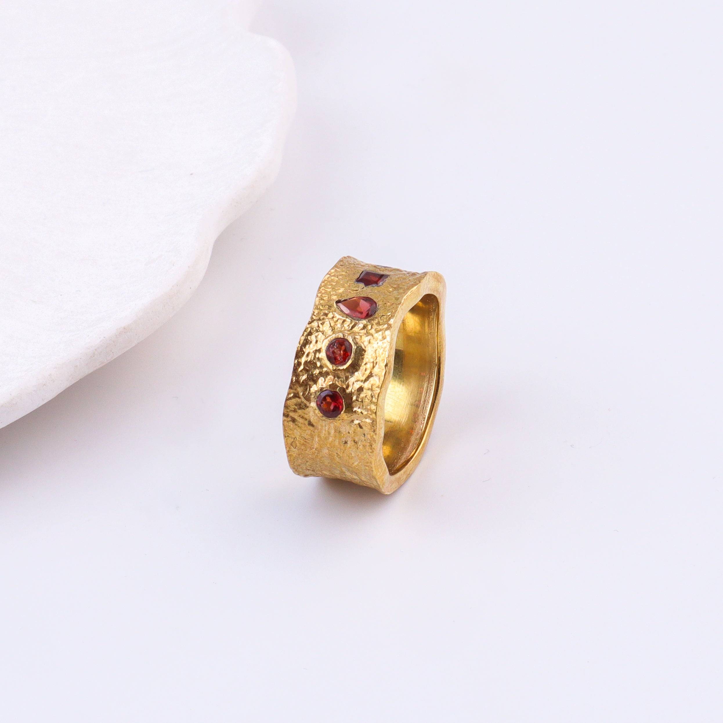 Angled view of a brass fashion ring highlighting its distinctive shape, structure, and polished brass finish