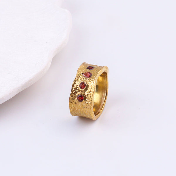 Angled view of a brass fashion ring highlighting its distinctive shape, structure, and polished brass finish