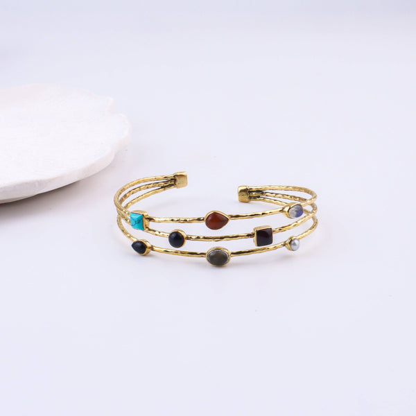 Detailed view of a brass fashion bracelet highlighting intricate motifs, textured surface, and refined brass finish