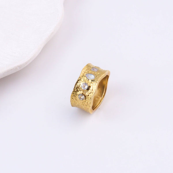 Angled view of a brass fashion ring highlighting its distinctive shape, structure, and polished brass finish