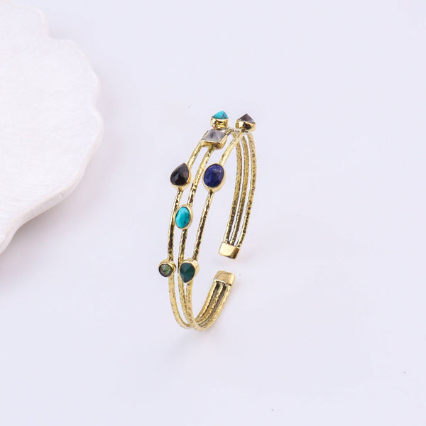 Detailed view of a brass fashion bracelet highlighting intricate motifs, textured surface, and refined brass finish