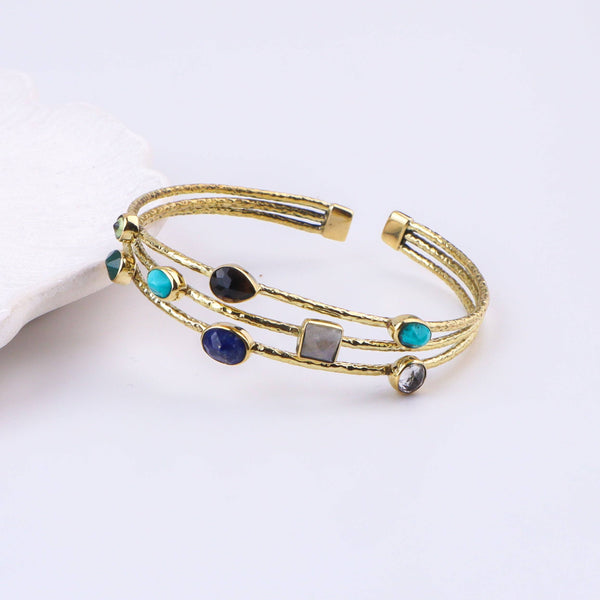 Angled view of a brass fashion bracelet highlighting its unique silhouette, structure, and polished brass finish