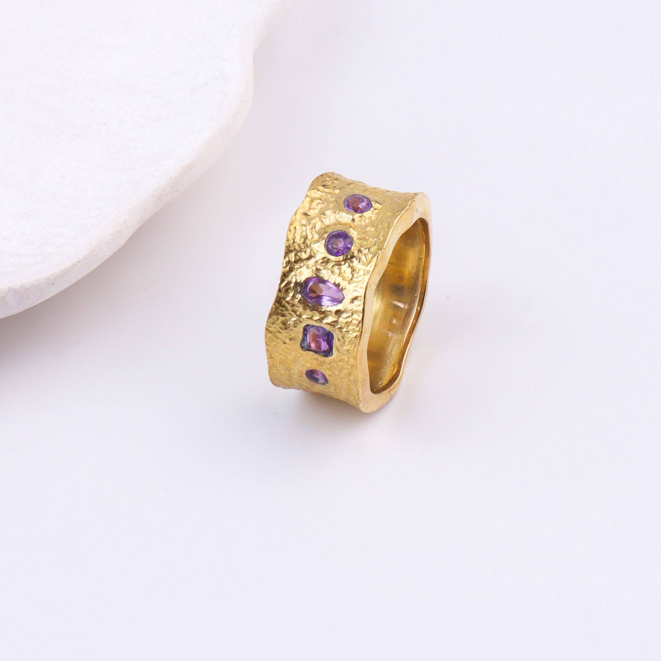 Angled view of a brass fashion ring highlighting its distinctive shape, structure, and polished brass finish