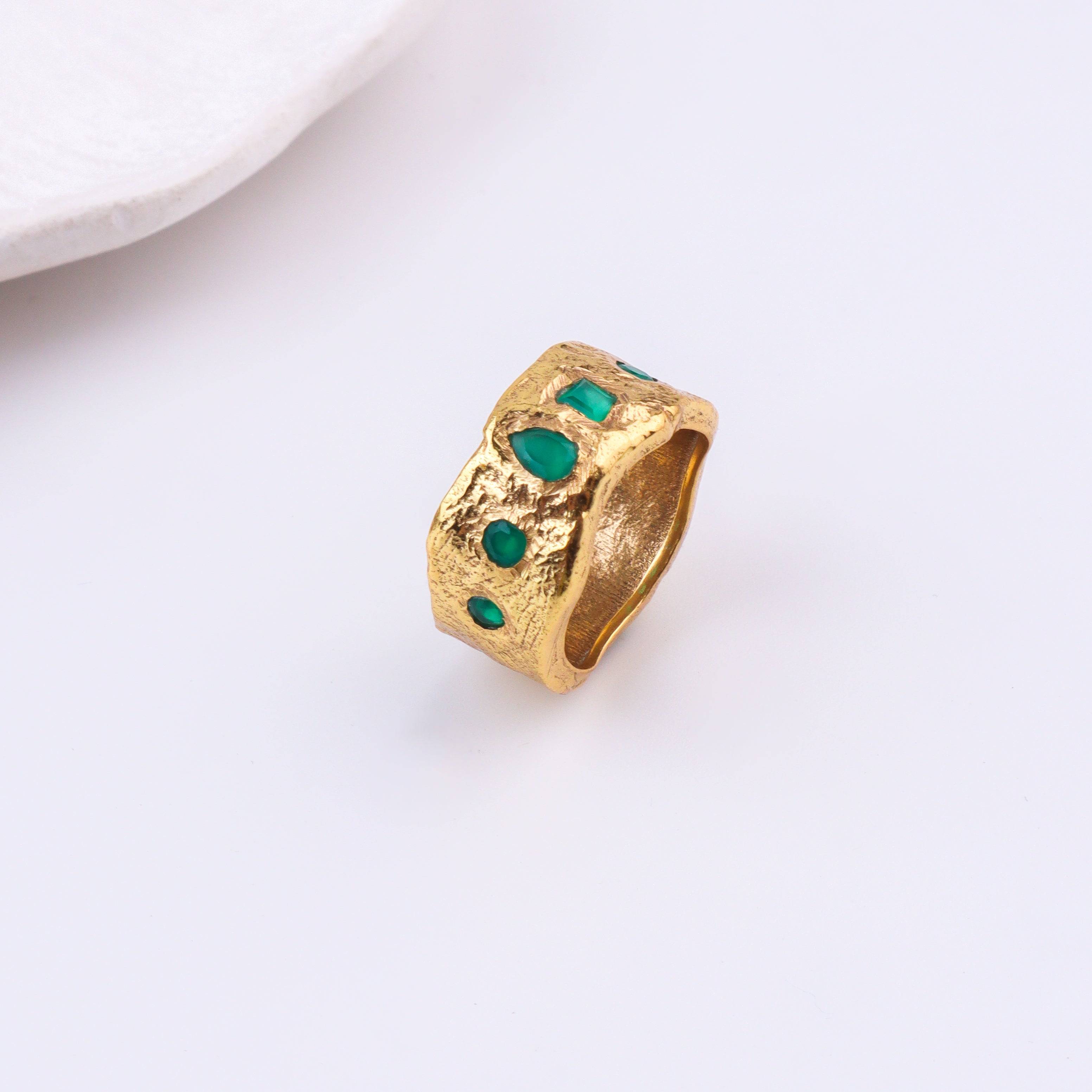 Angled view of a brass fashion ring highlighting its distinctive shape, structure, and polished brass finish