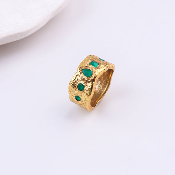 Angled view of a brass fashion ring highlighting its distinctive shape, structure, and polished brass finish