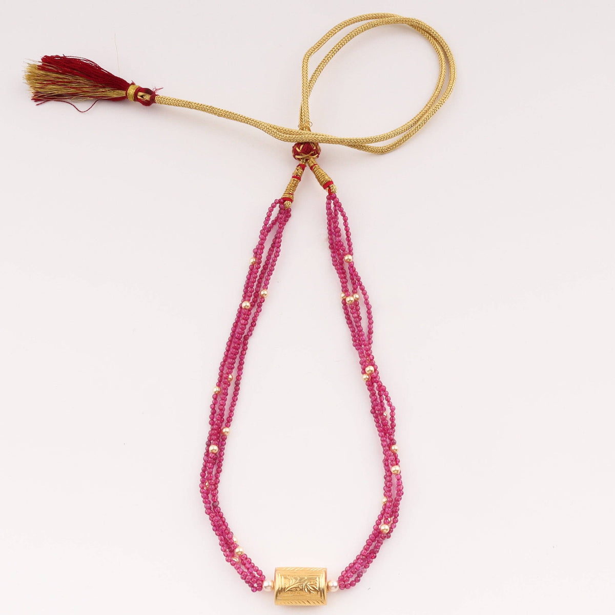 Gold and pink beaded necklace with tassel detail