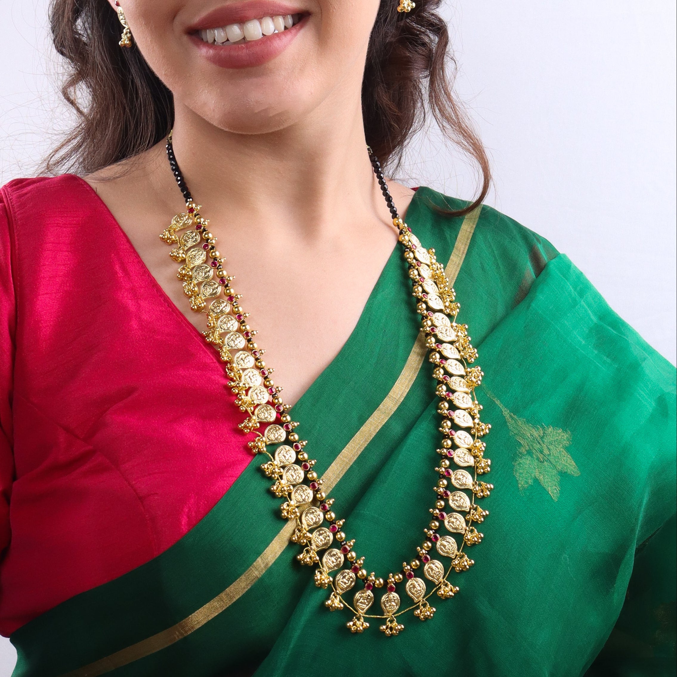 Traditional gold necklace with matching earrings on model
