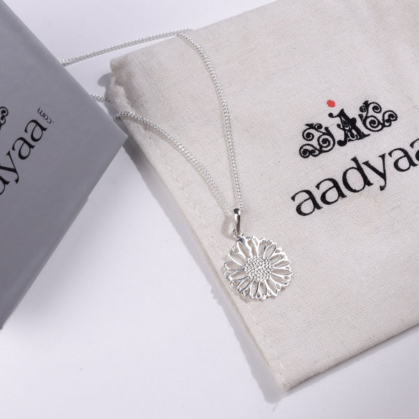 Silver floral pendant necklace on Aadyaa jewelry pouch