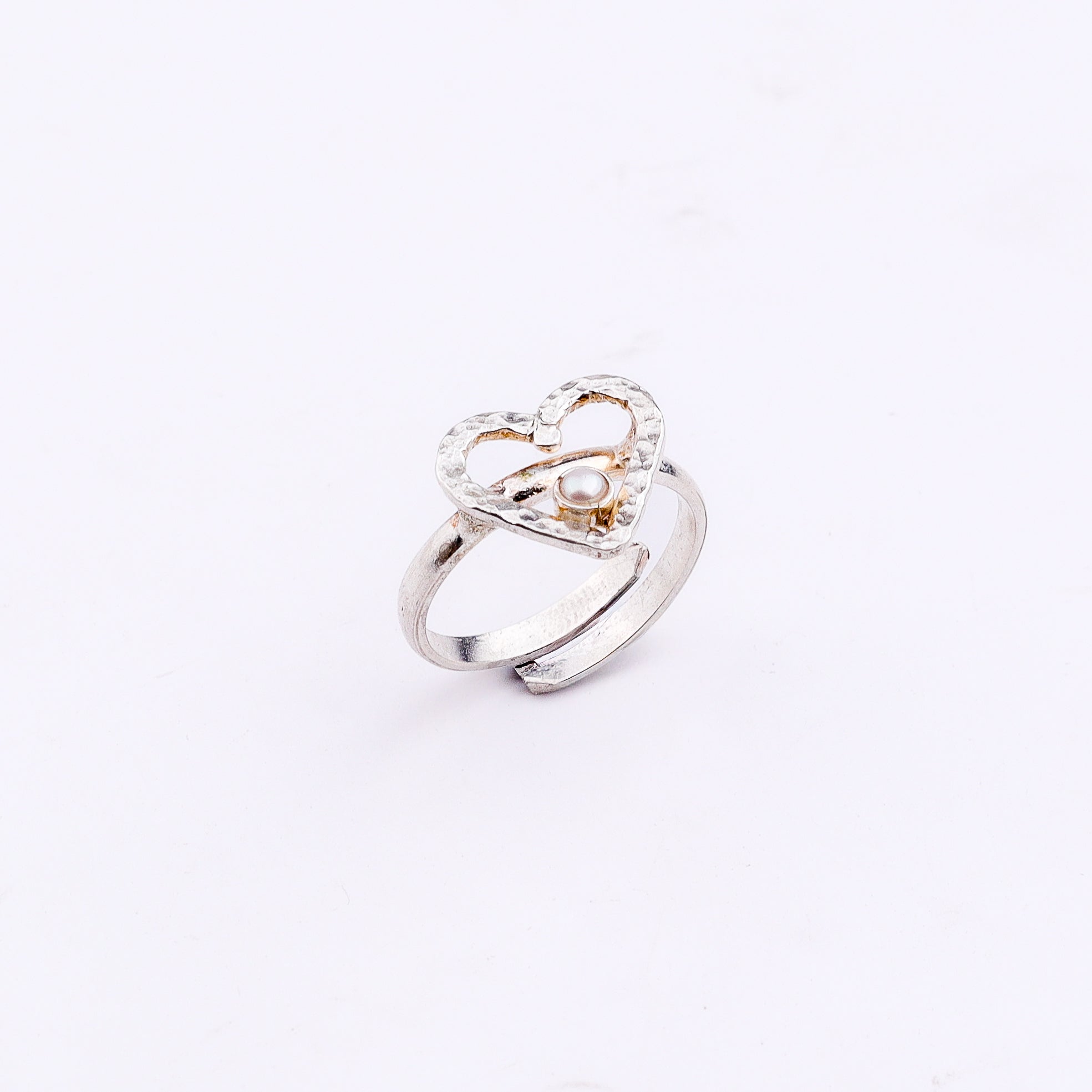 Silver heart pearl ring on white background