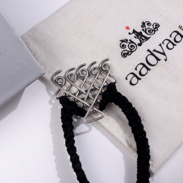 Silver Saraswati bracelet with black thread for men on Aadyaa jewelry pouch