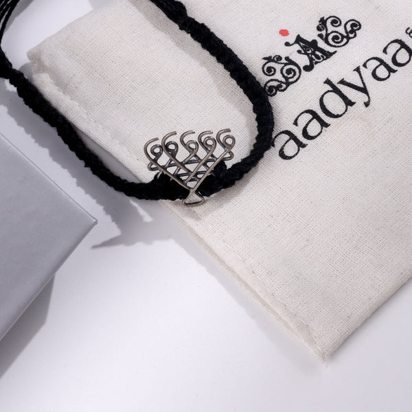 Silver Saraswati bracelet with black thread on Aadyaa jewelry pouch