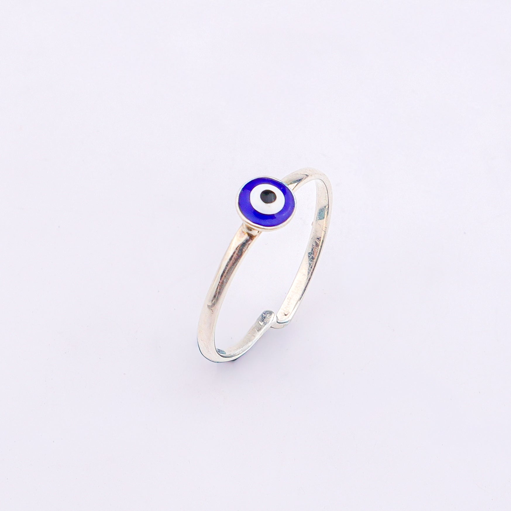 Silver evil eye ring on white background