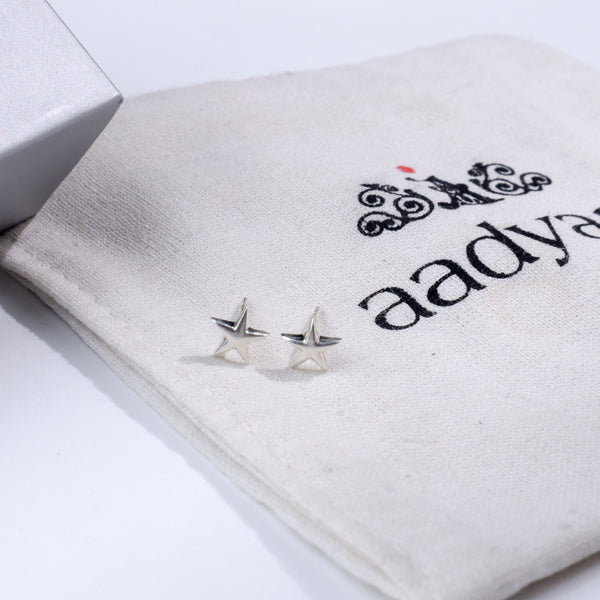 Silver starfish stud earrings on fabric pouch